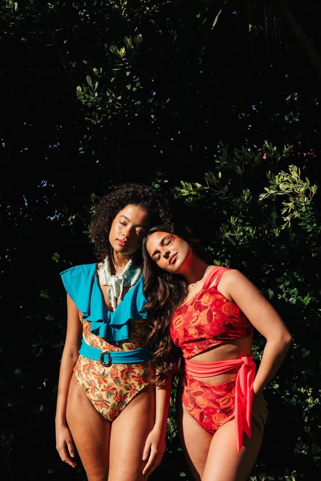 Duas mulheres encostadas uma à outra no jardim